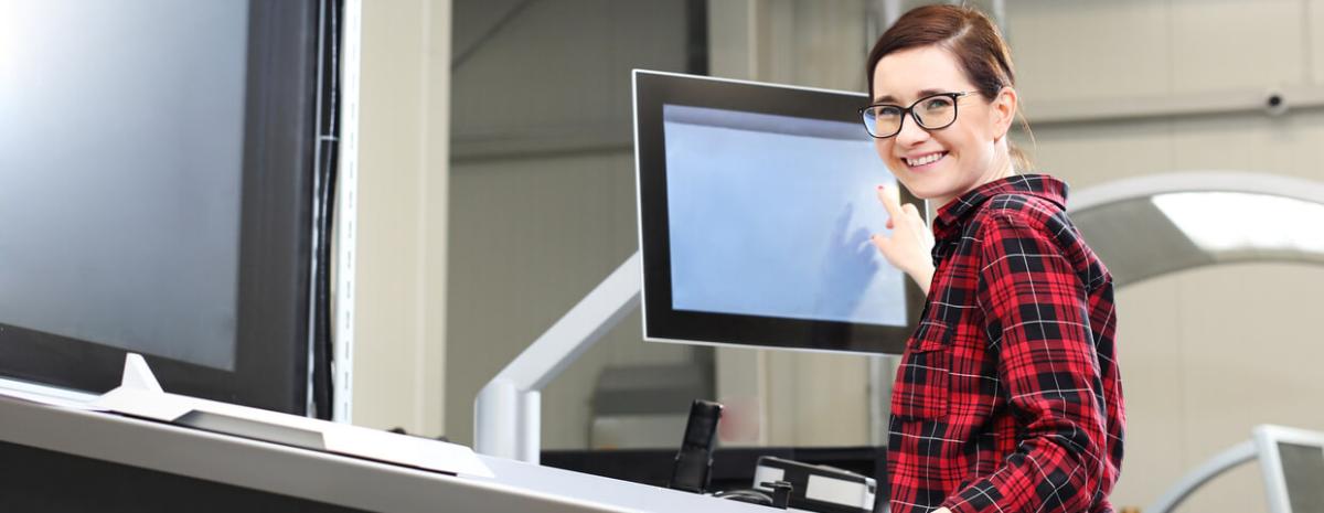 Woman smiling next to printer in office